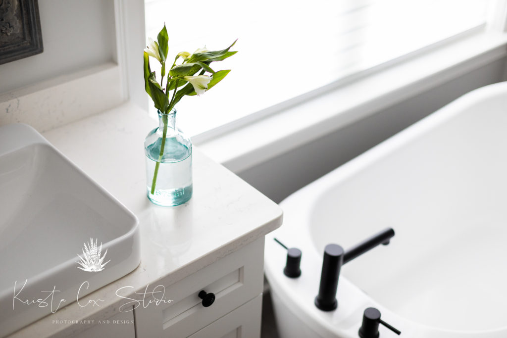 Interior photography of master bath featuring a closeup of the vanity and standalone tub.