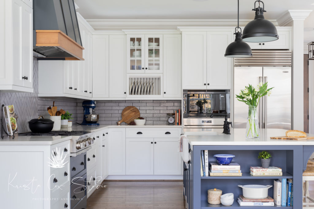 Interior photography of Gray and White kitchen featuring subway tile, gray island and barstools.