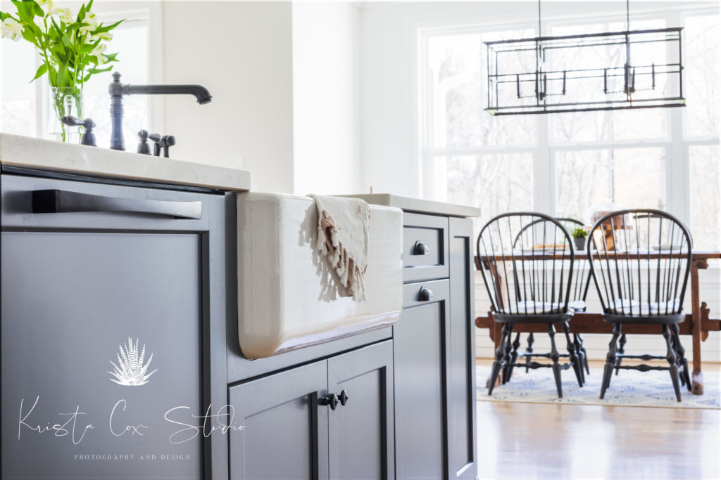 Interior photography of Gray and White kitchen featuring gray island with farm sink